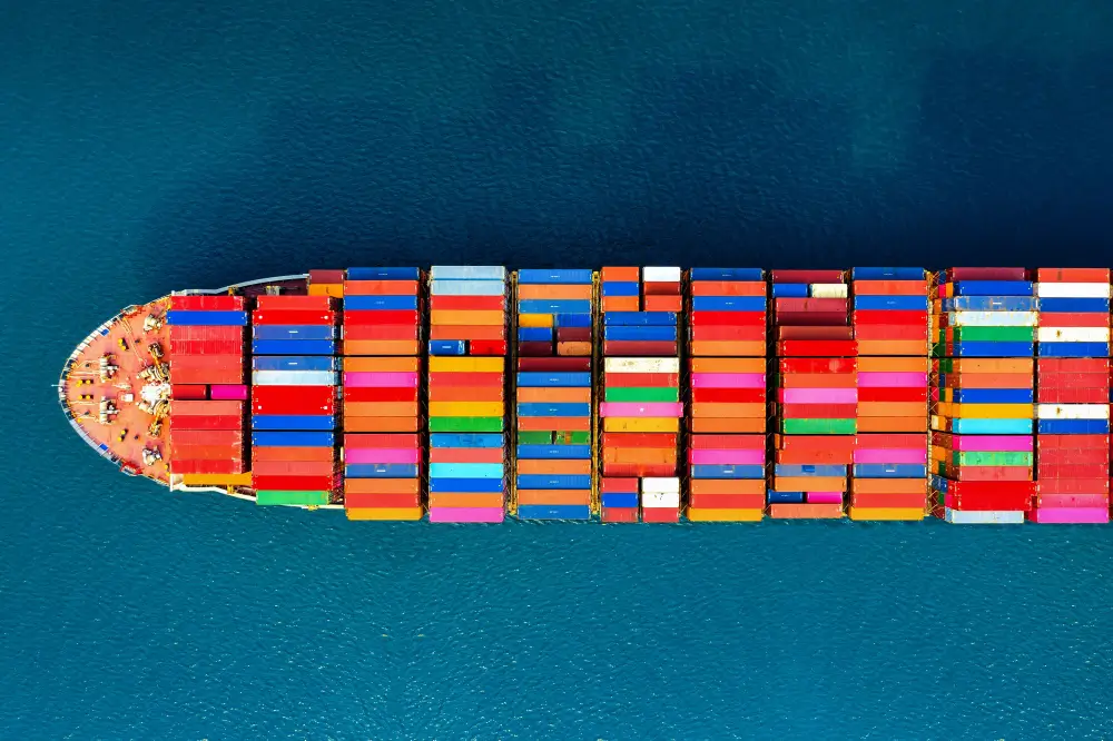 navio carregado de container navegando pelo oceano simbolizando frete internacional